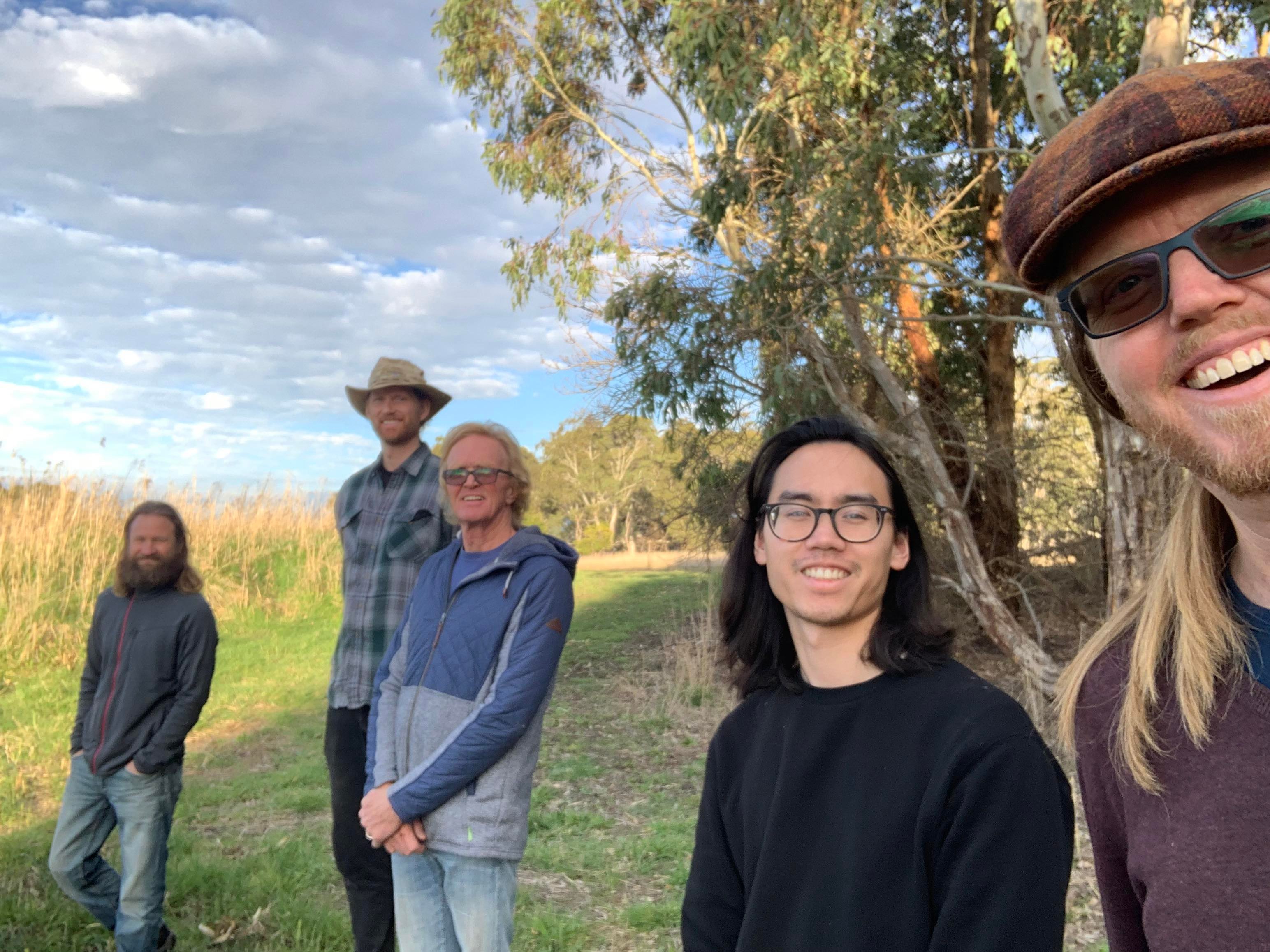 five men in a field smiling